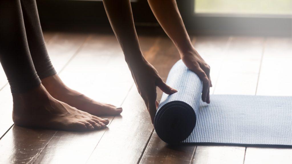 woman rolling up yoga mat