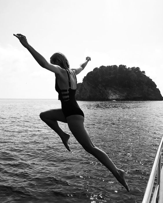 woman leaping into the ocean